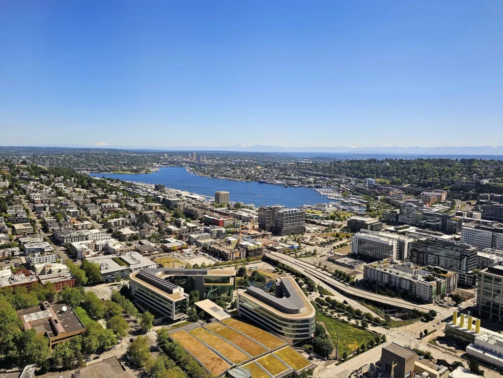 Cruising with Danny and Peter, Holland America Line, Westerdam, Seattle, Washington, United States, Day Trip Arctic Cruise | A vibrant collage capturing a day in Seattle, showcasing Lake Union’s serene waters reflecting the misty skyline with houseboats and kayakers, the towering Space Needle offering panoramic views of Puget Sound and Mount Rainier, and Chihuly Garden and Glass’s colorful glass sculptures blending with lush greenery. Pike Place Market buzzes with vendors tossing salmon and stalls brimming with flowers and artisanal goods under the iconic red sign. A cozy table at Villa Escondida displays tacos al pastor and enchiladas in a warm, mural-lined setting. The Seattle Great Wheel rises above Elliott Bay’s sparkling waterfront, while the Washington Park Arboretum’s tranquil paths feature blooming rhododendrons and a heron by a pond. The Japanese Garden’s koi pond, curved bridge, and stone lanterns create a Zen oasis, all set against Seattle’s dynamic blend of urban and natural beauty.