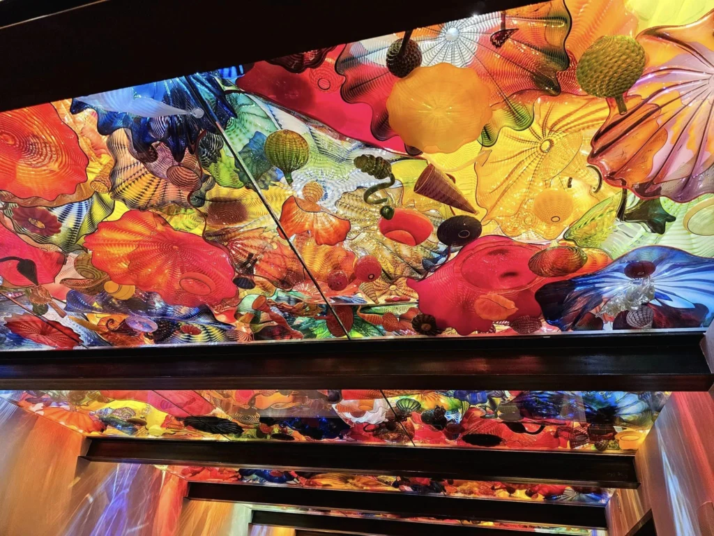 Cruising with Danny and Peter, Holland America Line, Westerdam, Seattle, Washington, United States, Day Trip Arctic Cruise | A vibrant collage capturing a day in Seattle, showcasing Lake Union’s serene waters reflecting the misty skyline with houseboats and kayakers, the towering Space Needle offering panoramic views of Puget Sound and Mount Rainier, and Chihuly Garden and Glass’s colorful glass sculptures blending with lush greenery. Pike Place Market buzzes with vendors tossing salmon and stalls brimming with flowers and artisanal goods under the iconic red sign. A cozy table at Villa Escondida displays tacos al pastor and enchiladas in a warm, mural-lined setting. The Seattle Great Wheel rises above Elliott Bay’s sparkling waterfront, while the Washington Park Arboretum’s tranquil paths feature blooming rhododendrons and a heron by a pond. The Japanese Garden’s koi pond, curved bridge, and stone lanterns create a Zen oasis, all set against Seattle’s dynamic blend of urban and natural beauty.