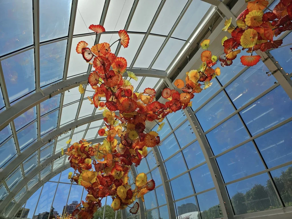 Cruising with Danny and Peter, Holland America Line, Westerdam, Seattle, Washington, United States, Day Trip Arctic Cruise | A vibrant collage capturing a day in Seattle, showcasing Lake Union’s serene waters reflecting the misty skyline with houseboats and kayakers, the towering Space Needle offering panoramic views of Puget Sound and Mount Rainier, and Chihuly Garden and Glass’s colorful glass sculptures blending with lush greenery. Pike Place Market buzzes with vendors tossing salmon and stalls brimming with flowers and artisanal goods under the iconic red sign. A cozy table at Villa Escondida displays tacos al pastor and enchiladas in a warm, mural-lined setting. The Seattle Great Wheel rises above Elliott Bay’s sparkling waterfront, while the Washington Park Arboretum’s tranquil paths feature blooming rhododendrons and a heron by a pond. The Japanese Garden’s koi pond, curved bridge, and stone lanterns create a Zen oasis, all set against Seattle’s dynamic blend of urban and natural beauty.