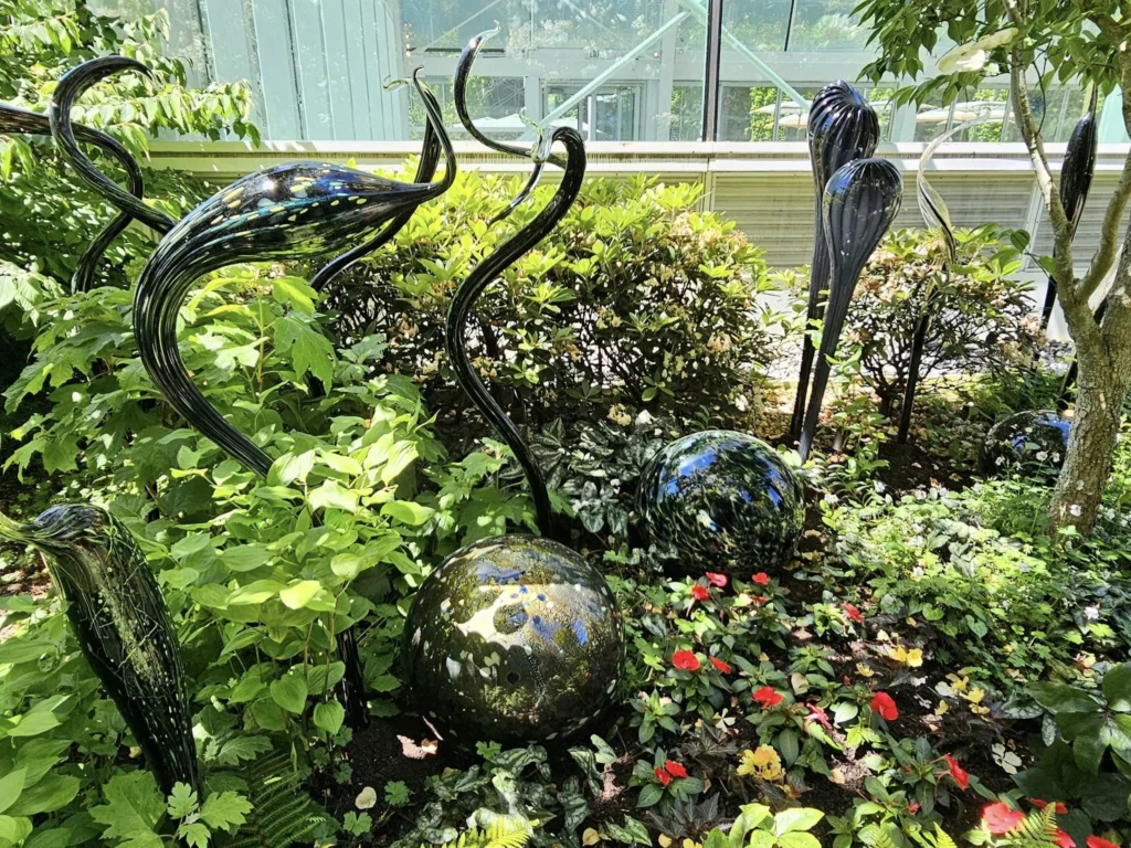 Cruising with Danny and Peter, Holland America Line, Westerdam, Seattle, Washington, United States, Day Trip Arctic Cruise | A vibrant collage capturing a day in Seattle, showcasing Lake Union’s serene waters reflecting the misty skyline with houseboats and kayakers, the towering Space Needle offering panoramic views of Puget Sound and Mount Rainier, and Chihuly Garden and Glass’s colorful glass sculptures blending with lush greenery. Pike Place Market buzzes with vendors tossing salmon and stalls brimming with flowers and artisanal goods under the iconic red sign. A cozy table at Villa Escondida displays tacos al pastor and enchiladas in a warm, mural-lined setting. The Seattle Great Wheel rises above Elliott Bay’s sparkling waterfront, while the Washington Park Arboretum’s tranquil paths feature blooming rhododendrons and a heron by a pond. The Japanese Garden’s koi pond, curved bridge, and stone lanterns create a Zen oasis, all set against Seattle’s dynamic blend of urban and natural beauty.