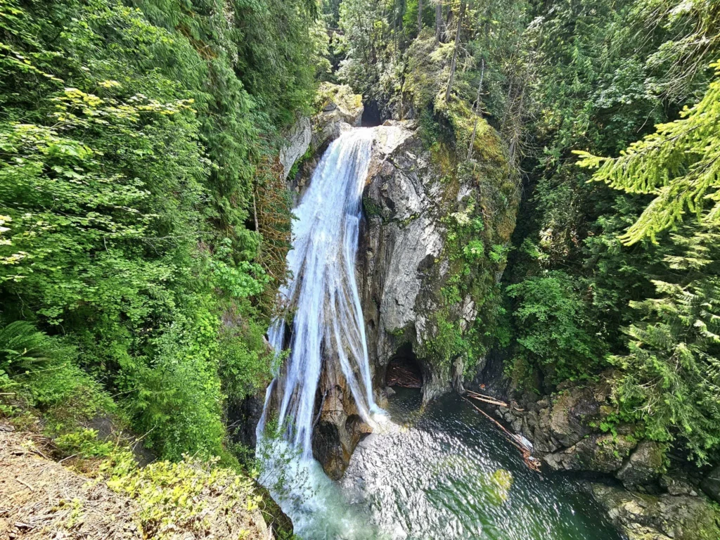 Cruising with Danny and Peter, Holland America Line, Westerdam, Seattle, Washington, United States, Day Trip Waterfalls History | A vibrant collage captures a day in Seattle’s Pacific Northwest Waterfalls Tour, showcasing Pike Place Market’s bustling scene with fishmongers tossing salmon and colorful flower stalls under the iconic red neon sign, set against Puget Sound’s waterfront; Twin Falls cascading over mossy cliffs into a misty pool, surrounded by old-growth evergreens in Olallie State Park, with sunlight filtering through the canopy; North Bend’s retro Twin Peaks diner with its glowing neon sign and quaint main street, framed by rolling hills and the Cascade Mountains; the majestic 270-foot Snoqualmie Falls roaring into a misty pool, with rainbows shimmering in the sunlight and a wooden viewing platform overlooking the lush Snoqualmie Valley; Snoqualmie’s historic district, featuring the Northwest Railway Museum’s vintage locomotives and charming shops lined with old-fashioned street lamps; Borst Lake’s serene waters reflecting Mount Si’s snow-capped peak, with a heron at the edge and evergreen forests under a soft morning mist; and the Museum of Flight’s sleek Concorde and Air Force One jets displayed in a spacious hangar, alongside interactive simulators and a replica of the International Space Station, showcasing Seattle’s aviation heritage.