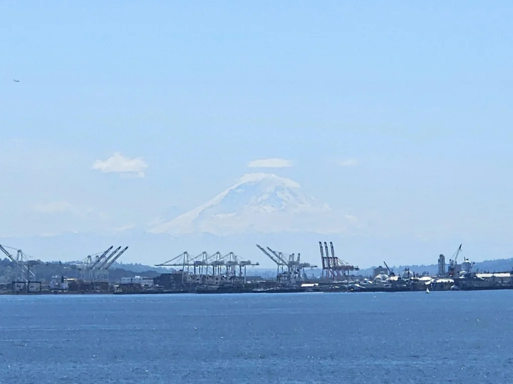 Cruising with Danny and Peter, Holland America Line, Westerdam, Seattle, Washington, United States, Alaska Solstice Cruise | A vibrant scene captures the Holland America Line’s Westerdam docked at Pier 91 in Seattle, Washington, with the iconic Space Needle and bustling Pike Place Market visible in the background, ready for the 28-Day Alaska Arctic Circle Solstice Cruise. The image showcases passengers excitedly boarding the ship, the luxurious stateroom with a spacious balcony offering stunning views of Elliott Bay, and the vessel setting sail from Seattle, marking the start of an unforgettable Alaskan adventure.