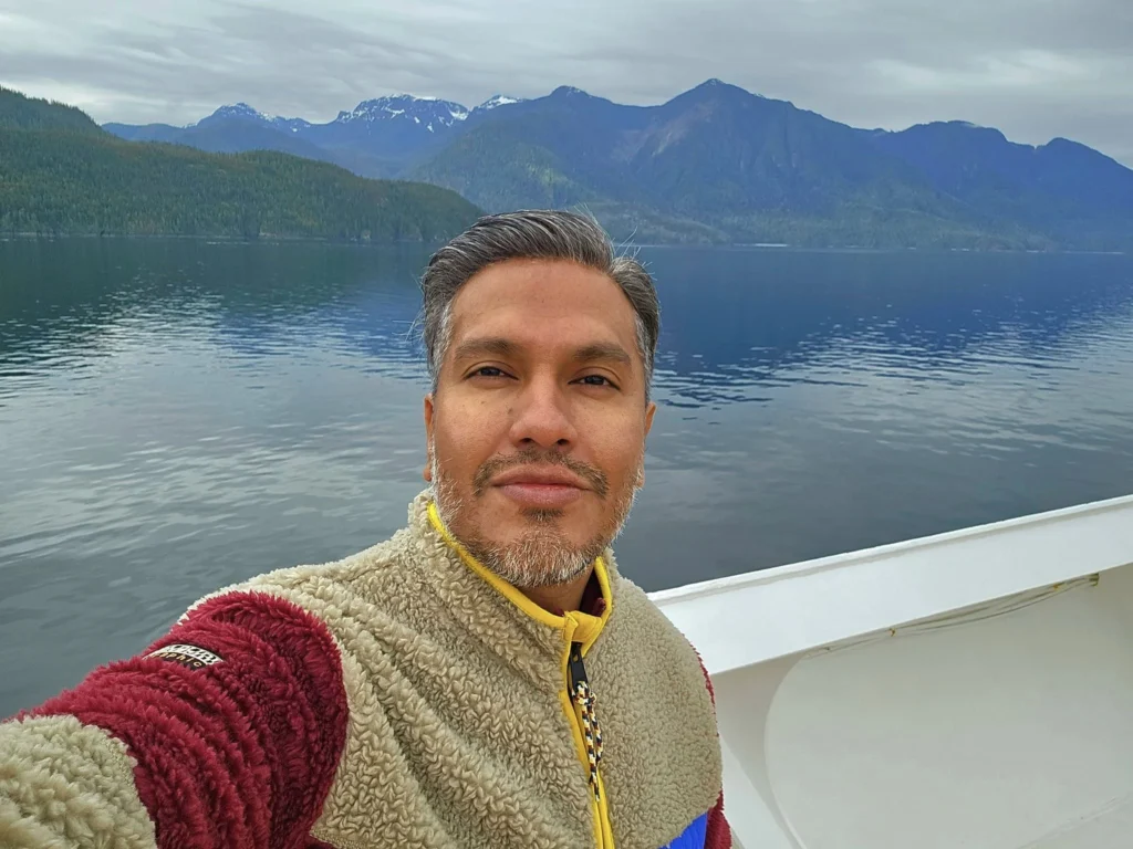 Cruising with Danny and Peter, Holland America Line, Westerdam, Inside Passage, Alaska, United States | Westerdam luxury cruise ship sailing through the Inside Passage, with majestic glaciers and dramatic landscapes in view. The image features an elegant stateroom with a spacious veranda, offering panoramic scenery, and highlights gourmet dining and an informative lecture by onboard naturalists, showcasing the comprehensive luxury and educational experience of the cruise.