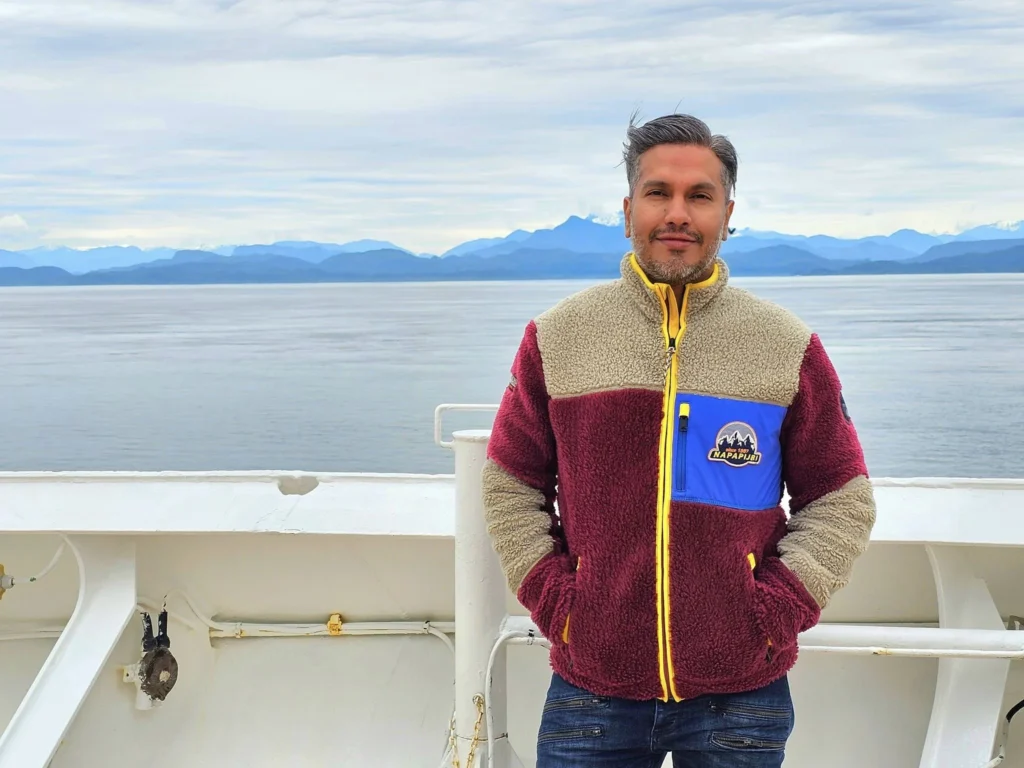 Cruising with Danny and Peter, Holland America Line, Westerdam, Inside Passage, Alaska, United States | Westerdam luxury cruise ship sailing through the Inside Passage, with majestic glaciers and dramatic landscapes in view. The image features an elegant stateroom with a spacious veranda, offering panoramic scenery, and highlights gourmet dining and an informative lecture by onboard naturalists, showcasing the comprehensive luxury and educational experience of the cruise.