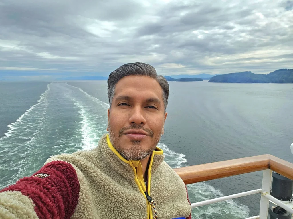 Cruising with Danny and Peter, Holland America Line, Westerdam, Inside Passage, Alaska, United States | Westerdam luxury cruise ship sailing through the Inside Passage, with majestic glaciers and dramatic landscapes in view. The image features an elegant stateroom with a spacious veranda, offering panoramic scenery, and highlights gourmet dining and an informative lecture by onboard naturalists, showcasing the comprehensive luxury and educational experience of the cruise.