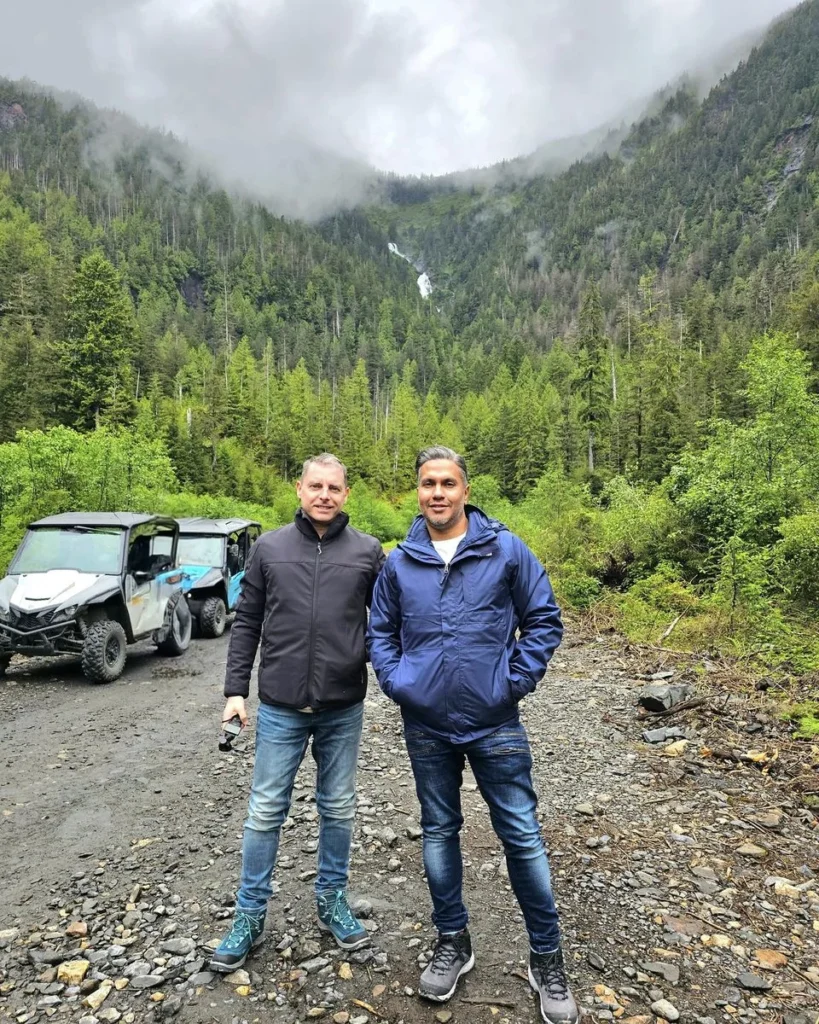 Cruising with Danny and Peter, Holland America Line, Westerdam, Ketchikan, Alaska, United States, Adventure History Thrills | A vibrant collage capturing the Ketchikan Adventure Tour in Alaska, featuring a dynamic log-rolling contest at the Great Alaskan Lumberjack Show with lumberjacks in plaid shirts balancing on a floating log, a rugged UTV navigating a muddy trail through the Tongass National Forest with George Inlet Fjords’ turquoise waters in view, a serene scenic cruise along the Inside Passage with a bald eagle soaring above mist-covered mountains, and a cozy scene at George Inlet Lodge with a rustic table set with craft beers, creamy crab chowder, hot Dungeness crab, and blueberry cheesecake. In the background, Ketchikan’s historic Creek Street showcases colorful buildings on stilts and a Tlingit totem pole, framed by lush greenery and rugged Alaskan peaks, embodying the city’s thrilling adventures and rich cultural heritage.