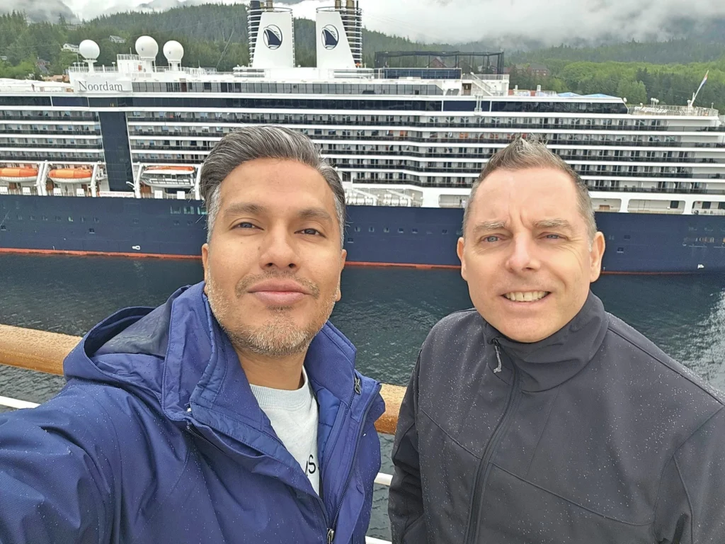 Cruising with Danny and Peter, Holland America Line, Westerdam, Ketchikan, Alaska, United States, Adventure History Thrills | A vibrant collage capturing the Ketchikan Adventure Tour in Alaska, featuring a dynamic log-rolling contest at the Great Alaskan Lumberjack Show with lumberjacks in plaid shirts balancing on a floating log, a rugged UTV navigating a muddy trail through the Tongass National Forest with George Inlet Fjords’ turquoise waters in view, a serene scenic cruise along the Inside Passage with a bald eagle soaring above mist-covered mountains, and a cozy scene at George Inlet Lodge with a rustic table set with craft beers, creamy crab chowder, hot Dungeness crab, and blueberry cheesecake. In the background, Ketchikan’s historic Creek Street showcases colorful buildings on stilts and a Tlingit totem pole, framed by lush greenery and rugged Alaskan peaks, embodying the city’s thrilling adventures and rich cultural heritage.