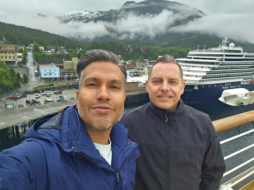 Cruising with Danny and Peter, Holland America Line, Westerdam, Ketchikan, Alaska, United States, Adventure History Thrills | A vibrant collage capturing the Ketchikan Adventure Tour in Alaska, featuring a dynamic log-rolling contest at the Great Alaskan Lumberjack Show with lumberjacks in plaid shirts balancing on a floating log, a rugged UTV navigating a muddy trail through the Tongass National Forest with George Inlet Fjords’ turquoise waters in view, a serene scenic cruise along the Inside Passage with a bald eagle soaring above mist-covered mountains, and a cozy scene at George Inlet Lodge with a rustic table set with craft beers, creamy crab chowder, hot Dungeness crab, and blueberry cheesecake. In the background, Ketchikan’s historic Creek Street showcases colorful buildings on stilts and a Tlingit totem pole, framed by lush greenery and rugged Alaskan peaks, embodying the city’s thrilling adventures and rich cultural heritage.