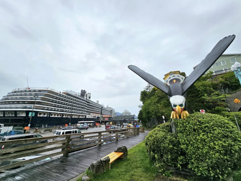 Cruising with Danny and Peter, Holland America Line, Westerdam, Ketchikan, Alaska, United States, Adventure History Thrills | A vibrant collage capturing the Ketchikan Adventure Tour in Alaska, featuring a dynamic log-rolling contest at the Great Alaskan Lumberjack Show with lumberjacks in plaid shirts balancing on a floating log, a rugged UTV navigating a muddy trail through the Tongass National Forest with George Inlet Fjords’ turquoise waters in view, a serene scenic cruise along the Inside Passage with a bald eagle soaring above mist-covered mountains, and a cozy scene at George Inlet Lodge with a rustic table set with craft beers, creamy crab chowder, hot Dungeness crab, and blueberry cheesecake. In the background, Ketchikan’s historic Creek Street showcases colorful buildings on stilts and a Tlingit totem pole, framed by lush greenery and rugged Alaskan peaks, embodying the city’s thrilling adventures and rich cultural heritage.