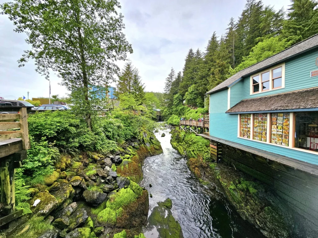 Cruising with Danny and Peter, Holland America Line, Westerdam, Ketchikan, Alaska, United States, Adventure History Thrills | A vibrant collage capturing the Ketchikan Adventure Tour in Alaska, featuring a dynamic log-rolling contest at the Great Alaskan Lumberjack Show with lumberjacks in plaid shirts balancing on a floating log, a rugged UTV navigating a muddy trail through the Tongass National Forest with George Inlet Fjords’ turquoise waters in view, a serene scenic cruise along the Inside Passage with a bald eagle soaring above mist-covered mountains, and a cozy scene at George Inlet Lodge with a rustic table set with craft beers, creamy crab chowder, hot Dungeness crab, and blueberry cheesecake. In the background, Ketchikan’s historic Creek Street showcases colorful buildings on stilts and a Tlingit totem pole, framed by lush greenery and rugged Alaskan peaks, embodying the city’s thrilling adventures and rich cultural heritage.
