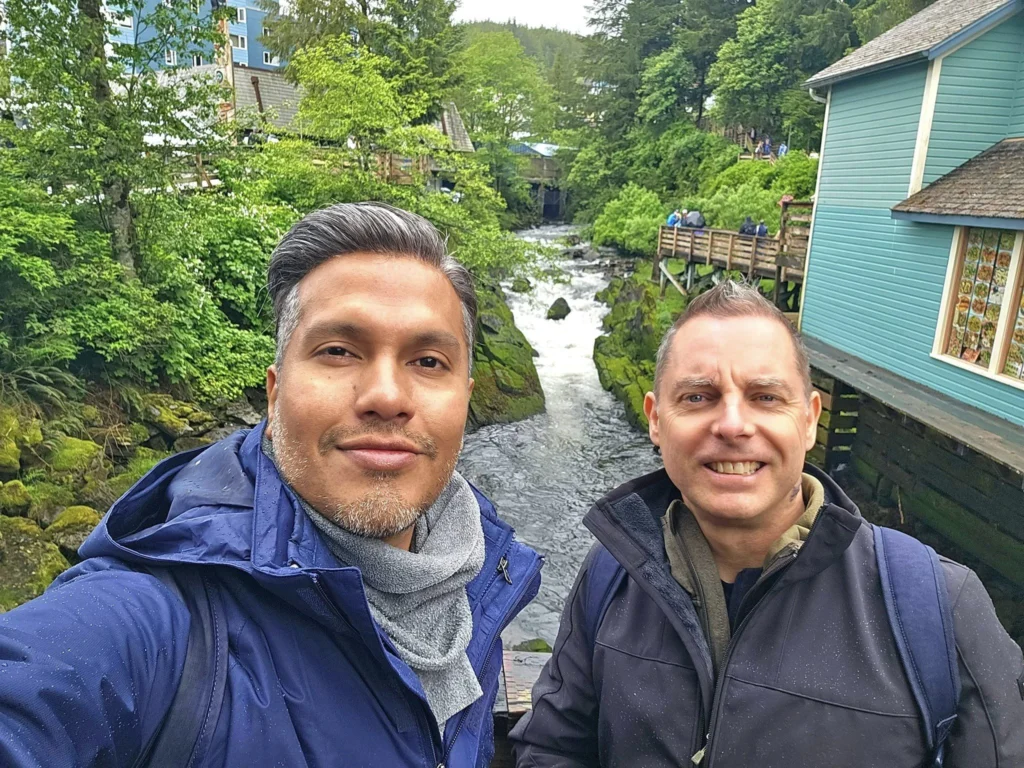 Cruising with Danny and Peter, Holland America Line, Westerdam, Ketchikan, Alaska, United States, Adventure History Thrills | A vibrant collage capturing the Ketchikan Adventure Tour in Alaska, featuring a dynamic log-rolling contest at the Great Alaskan Lumberjack Show with lumberjacks in plaid shirts balancing on a floating log, a rugged UTV navigating a muddy trail through the Tongass National Forest with George Inlet Fjords’ turquoise waters in view, a serene scenic cruise along the Inside Passage with a bald eagle soaring above mist-covered mountains, and a cozy scene at George Inlet Lodge with a rustic table set with craft beers, creamy crab chowder, hot Dungeness crab, and blueberry cheesecake. In the background, Ketchikan’s historic Creek Street showcases colorful buildings on stilts and a Tlingit totem pole, framed by lush greenery and rugged Alaskan peaks, embodying the city’s thrilling adventures and rich cultural heritage.