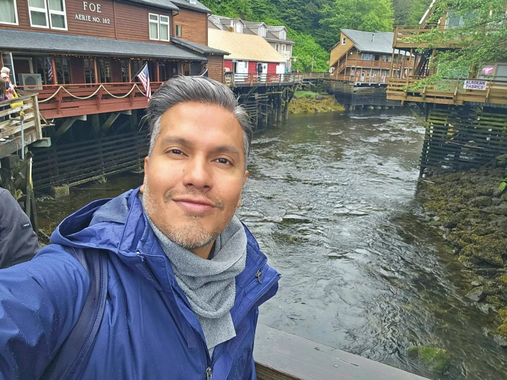 Cruising with Danny and Peter, Holland America Line, Westerdam, Ketchikan, Alaska, United States, Adventure History Thrills | A vibrant collage capturing the Ketchikan Adventure Tour in Alaska, featuring a dynamic log-rolling contest at the Great Alaskan Lumberjack Show with lumberjacks in plaid shirts balancing on a floating log, a rugged UTV navigating a muddy trail through the Tongass National Forest with George Inlet Fjords’ turquoise waters in view, a serene scenic cruise along the Inside Passage with a bald eagle soaring above mist-covered mountains, and a cozy scene at George Inlet Lodge with a rustic table set with craft beers, creamy crab chowder, hot Dungeness crab, and blueberry cheesecake. In the background, Ketchikan’s historic Creek Street showcases colorful buildings on stilts and a Tlingit totem pole, framed by lush greenery and rugged Alaskan peaks, embodying the city’s thrilling adventures and rich cultural heritage.