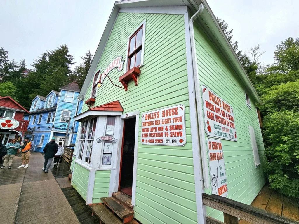 Cruising with Danny and Peter, Holland America Line, Westerdam, Ketchikan, Alaska, United States, Adventure History Thrills | A vibrant collage capturing the Ketchikan Adventure Tour in Alaska, featuring a dynamic log-rolling contest at the Great Alaskan Lumberjack Show with lumberjacks in plaid shirts balancing on a floating log, a rugged UTV navigating a muddy trail through the Tongass National Forest with George Inlet Fjords’ turquoise waters in view, a serene scenic cruise along the Inside Passage with a bald eagle soaring above mist-covered mountains, and a cozy scene at George Inlet Lodge with a rustic table set with craft beers, creamy crab chowder, hot Dungeness crab, and blueberry cheesecake. In the background, Ketchikan’s historic Creek Street showcases colorful buildings on stilts and a Tlingit totem pole, framed by lush greenery and rugged Alaskan peaks, embodying the city’s thrilling adventures and rich cultural heritage.