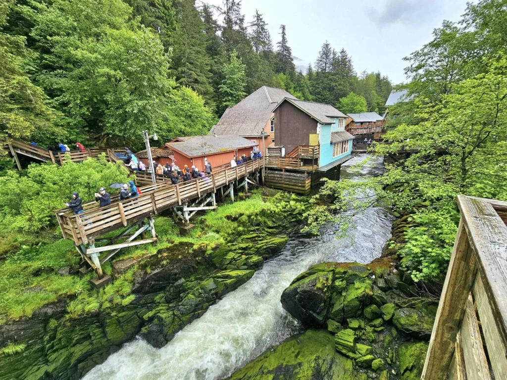 Cruising with Danny and Peter, Holland America Line, Westerdam, Ketchikan, Alaska, United States, Adventure History Thrills | A vibrant collage capturing the Ketchikan Adventure Tour in Alaska, featuring a dynamic log-rolling contest at the Great Alaskan Lumberjack Show with lumberjacks in plaid shirts balancing on a floating log, a rugged UTV navigating a muddy trail through the Tongass National Forest with George Inlet Fjords’ turquoise waters in view, a serene scenic cruise along the Inside Passage with a bald eagle soaring above mist-covered mountains, and a cozy scene at George Inlet Lodge with a rustic table set with craft beers, creamy crab chowder, hot Dungeness crab, and blueberry cheesecake. In the background, Ketchikan’s historic Creek Street showcases colorful buildings on stilts and a Tlingit totem pole, framed by lush greenery and rugged Alaskan peaks, embodying the city’s thrilling adventures and rich cultural heritage.