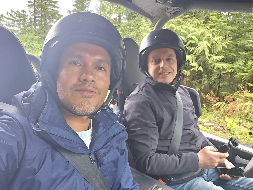 Cruising with Danny and Peter, Holland America Line, Westerdam, Ketchikan, Alaska, United States, Adventure History Thrills | A vibrant collage capturing the Ketchikan Adventure Tour in Alaska, featuring a dynamic log-rolling contest at the Great Alaskan Lumberjack Show with lumberjacks in plaid shirts balancing on a floating log, a rugged UTV navigating a muddy trail through the Tongass National Forest with George Inlet Fjords’ turquoise waters in view, a serene scenic cruise along the Inside Passage with a bald eagle soaring above mist-covered mountains, and a cozy scene at George Inlet Lodge with a rustic table set with craft beers, creamy crab chowder, hot Dungeness crab, and blueberry cheesecake. In the background, Ketchikan’s historic Creek Street showcases colorful buildings on stilts and a Tlingit totem pole, framed by lush greenery and rugged Alaskan peaks, embodying the city’s thrilling adventures and rich cultural heritage.