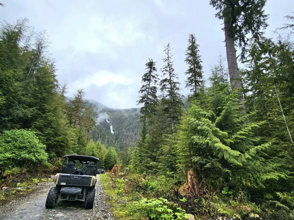 Cruising with Danny and Peter, Holland America Line, Westerdam, Ketchikan, Alaska, United States, Adventure History Thrills | A vibrant collage capturing the Ketchikan Adventure Tour in Alaska, featuring a dynamic log-rolling contest at the Great Alaskan Lumberjack Show with lumberjacks in plaid shirts balancing on a floating log, a rugged UTV navigating a muddy trail through the Tongass National Forest with George Inlet Fjords’ turquoise waters in view, a serene scenic cruise along the Inside Passage with a bald eagle soaring above mist-covered mountains, and a cozy scene at George Inlet Lodge with a rustic table set with craft beers, creamy crab chowder, hot Dungeness crab, and blueberry cheesecake. In the background, Ketchikan’s historic Creek Street showcases colorful buildings on stilts and a Tlingit totem pole, framed by lush greenery and rugged Alaskan peaks, embodying the city’s thrilling adventures and rich cultural heritage.
