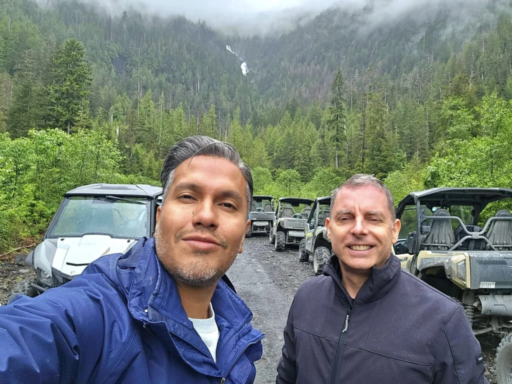 Cruising with Danny and Peter, Holland America Line, Westerdam, Ketchikan, Alaska, United States, Adventure History Thrills | A vibrant collage capturing the Ketchikan Adventure Tour in Alaska, featuring a dynamic log-rolling contest at the Great Alaskan Lumberjack Show with lumberjacks in plaid shirts balancing on a floating log, a rugged UTV navigating a muddy trail through the Tongass National Forest with George Inlet Fjords’ turquoise waters in view, a serene scenic cruise along the Inside Passage with a bald eagle soaring above mist-covered mountains, and a cozy scene at George Inlet Lodge with a rustic table set with craft beers, creamy crab chowder, hot Dungeness crab, and blueberry cheesecake. In the background, Ketchikan’s historic Creek Street showcases colorful buildings on stilts and a Tlingit totem pole, framed by lush greenery and rugged Alaskan peaks, embodying the city’s thrilling adventures and rich cultural heritage.