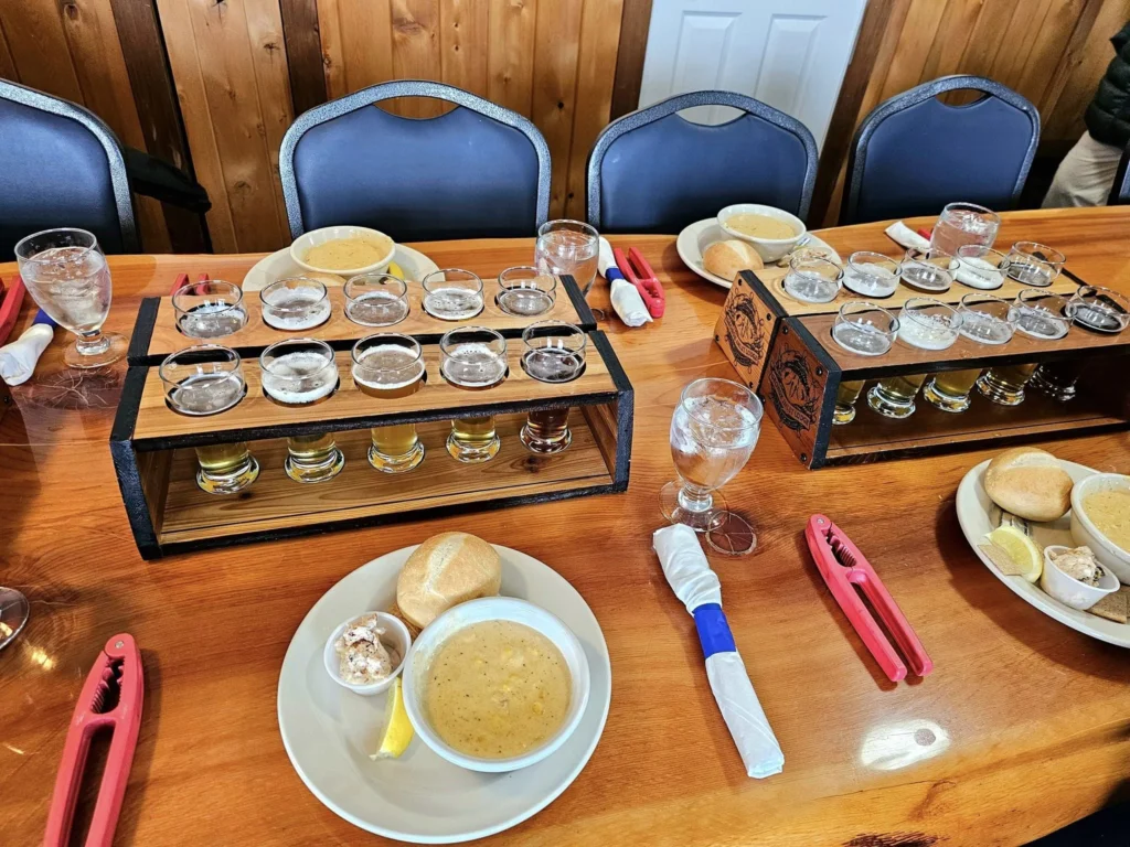 Cruising with Danny and Peter, Holland America Line, Westerdam, Ketchikan, Alaska, United States, Adventure History Thrills | A vibrant collage capturing the Ketchikan Adventure Tour in Alaska, featuring a dynamic log-rolling contest at the Great Alaskan Lumberjack Show with lumberjacks in plaid shirts balancing on a floating log, a rugged UTV navigating a muddy trail through the Tongass National Forest with George Inlet Fjords’ turquoise waters in view, a serene scenic cruise along the Inside Passage with a bald eagle soaring above mist-covered mountains, and a cozy scene at George Inlet Lodge with a rustic table set with craft beers, creamy crab chowder, hot Dungeness crab, and blueberry cheesecake. In the background, Ketchikan’s historic Creek Street showcases colorful buildings on stilts and a Tlingit totem pole, framed by lush greenery and rugged Alaskan peaks, embodying the city’s thrilling adventures and rich cultural heritage.