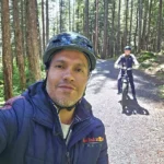 Cruising with Danny and Peter, Holland America Line, Westerdam, Sitka, Alaska, United States | Biking the scenic Sitka Cross Trail through lush Alaskan forests, capturing Sitka's natural beauty and outdoor adventure; a whale breaching in Whale Park, showcasing Sitka Alaska's wildlife; a majestic eagle soaring above, symbolizing the rich wildlife; and an intricate Tlingit totem pole representing the cultural heritage of Sitka, Alaska, all set against the stunning coastal landscape of this Alaskan gem.