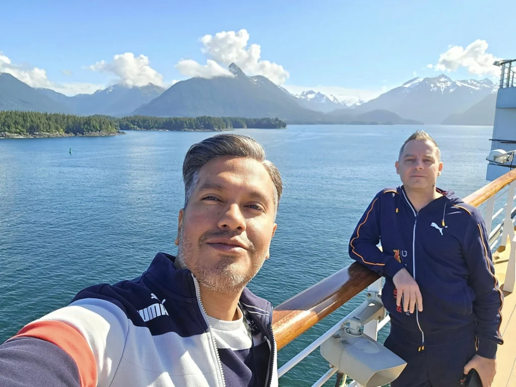 Cruising with Danny and Peter, Holland America Line, Westerdam, Sitka, Alaska, United States | Biking the scenic Sitka Cross Trail through lush Alaskan forests, capturing Sitka's natural beauty and outdoor adventure; a whale breaching in Whale Park, showcasing Sitka Alaska's wildlife; a majestic eagle soaring above, symbolizing the rich wildlife; and an intricate Tlingit totem pole representing the cultural heritage of Sitka, Alaska, all set against the stunning coastal landscape of this Alaskan gem.