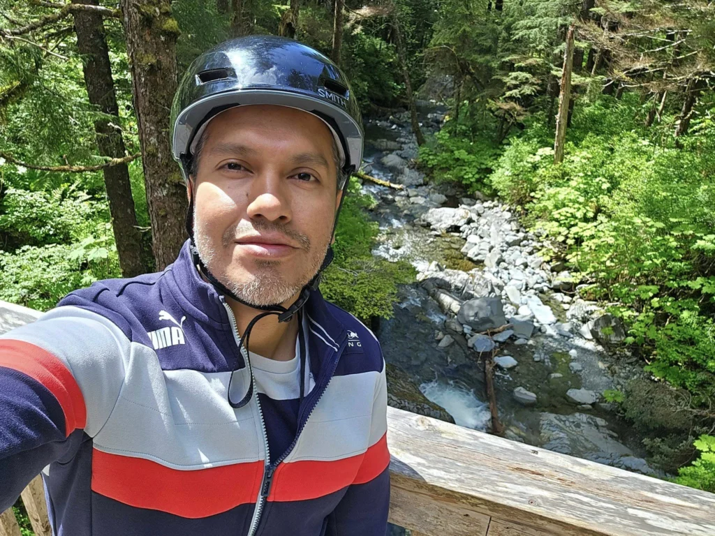 Cruising with Danny and Peter, Holland America Line, Westerdam, Sitka, Alaska, United States | Biking the scenic Sitka Cross Trail through lush Alaskan forests, capturing Sitka's natural beauty and outdoor adventure; a whale breaching in Whale Park, showcasing Sitka Alaska's wildlife; a majestic eagle soaring above, symbolizing the rich wildlife; and an intricate Tlingit totem pole representing the cultural heritage of Sitka, Alaska, all set against the stunning coastal landscape of this Alaskan gem.