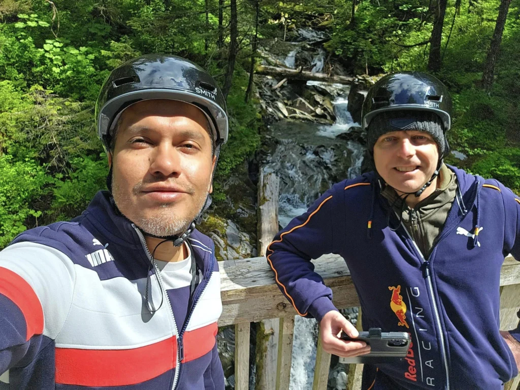 Cruising with Danny and Peter, Holland America Line, Westerdam, Sitka, Alaska, United States | Biking the scenic Sitka Cross Trail through lush Alaskan forests, capturing Sitka's natural beauty and outdoor adventure; a whale breaching in Whale Park, showcasing Sitka Alaska's wildlife; a majestic eagle soaring above, symbolizing the rich wildlife; and an intricate Tlingit totem pole representing the cultural heritage of Sitka, Alaska, all set against the stunning coastal landscape of this Alaskan gem.