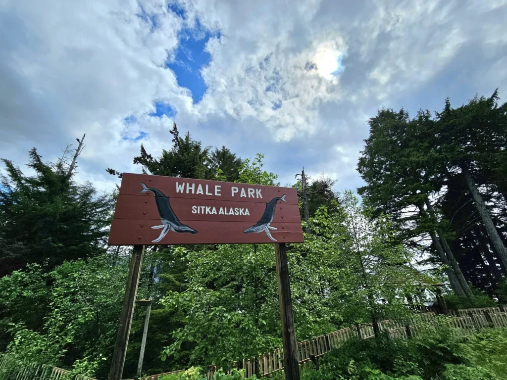 Cruising with Danny and Peter, Holland America Line, Westerdam, Sitka, Alaska, United States | Biking the scenic Sitka Cross Trail through lush Alaskan forests, capturing Sitka's natural beauty and outdoor adventure; a whale breaching in Whale Park, showcasing Sitka Alaska's wildlife; a majestic eagle soaring above, symbolizing the rich wildlife; and an intricate Tlingit totem pole representing the cultural heritage of Sitka, Alaska, all set against the stunning coastal landscape of this Alaskan gem.