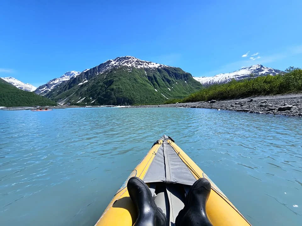 Cruising with Danny and Peter, Holland America Line, Westerdam, Prince William Sound, Valdez, Alaska, United States | A serene panorama of Prince William Sound at dawn, with the luxurious Westerdam cruise ship gliding through calm waters, surrounded by snow-capped mountains and glowing glaciers under a soft pink sky. Humpback whales breach the surface, their tails splashing against the reflective water, while sea otters float playfully in kelp beds and a bald eagle soars overhead. In Valdez Glacier Lake, vibrant blue icebergs drift peacefully, with kayakers in colorful kayaks paddling through the icy maze, dwarfed by the towering Valdez Glacier’s rugged ice face in the background. The Westerdam’s elegant deck features passengers enjoying a gourmet breakfast with panoramic views of the Alaskan wilderness, capturing the harmonious blend of luxury and nature.