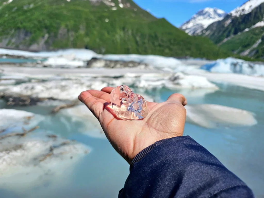 Cruising with Danny and Peter, Holland America Line, Westerdam, Prince William Sound, Valdez, Alaska, United States | A serene panorama of Prince William Sound at dawn, with the luxurious Westerdam cruise ship gliding through calm waters, surrounded by snow-capped mountains and glowing glaciers under a soft pink sky. Humpback whales breach the surface, their tails splashing against the reflective water, while sea otters float playfully in kelp beds and a bald eagle soars overhead. In Valdez Glacier Lake, vibrant blue icebergs drift peacefully, with kayakers in colorful kayaks paddling through the icy maze, dwarfed by the towering Valdez Glacier’s rugged ice face in the background. The Westerdam’s elegant deck features passengers enjoying a gourmet breakfast with panoramic views of the Alaskan wilderness, capturing the harmonious blend of luxury and nature.
