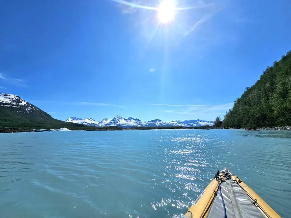 Cruising with Danny and Peter, Holland America Line, Westerdam, Prince William Sound, Valdez, Alaska, United States | A serene panorama of Prince William Sound at dawn, with the luxurious Westerdam cruise ship gliding through calm waters, surrounded by snow-capped mountains and glowing glaciers under a soft pink sky. Humpback whales breach the surface, their tails splashing against the reflective water, while sea otters float playfully in kelp beds and a bald eagle soars overhead. In Valdez Glacier Lake, vibrant blue icebergs drift peacefully, with kayakers in colorful kayaks paddling through the icy maze, dwarfed by the towering Valdez Glacier’s rugged ice face in the background. The Westerdam’s elegant deck features passengers enjoying a gourmet breakfast with panoramic views of the Alaskan wilderness, capturing the harmonious blend of luxury and nature.