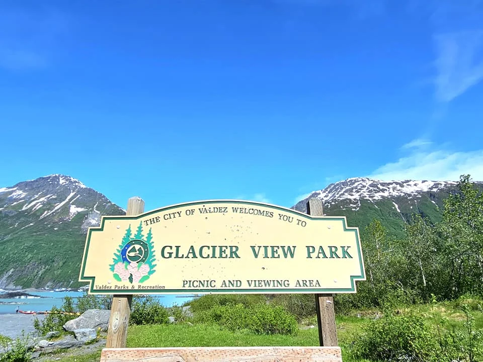 Cruising with Danny and Peter, Holland America Line, Westerdam, Prince William Sound, Valdez, Alaska, United States | A serene panorama of Prince William Sound at dawn, with the luxurious Westerdam cruise ship gliding through calm waters, surrounded by snow-capped mountains and glowing glaciers under a soft pink sky. Humpback whales breach the surface, their tails splashing against the reflective water, while sea otters float playfully in kelp beds and a bald eagle soars overhead. In Valdez Glacier Lake, vibrant blue icebergs drift peacefully, with kayakers in colorful kayaks paddling through the icy maze, dwarfed by the towering Valdez Glacier’s rugged ice face in the background. The Westerdam’s elegant deck features passengers enjoying a gourmet breakfast with panoramic views of the Alaskan wilderness, capturing the harmonious blend of luxury and nature.