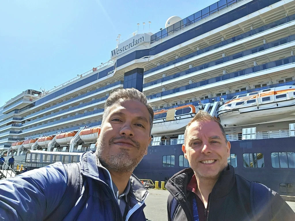 Cruising with Danny and Peter, Holland America Line, Westerdam, Seward, Alaska, United States | A panoramic view of Seward Harbor with rugged cliffs and serene waters, capturing Alaska's wilderness on a photography adventure. Travelers document vibrant wildflowers and snow-capped peaks in Chugach National Forest during an Alaska wilderness cruise. Historical remnants of the 1890 Gold Rush in Seward, including old mining equipment in lush alpine meadows, offer perfect scenes for photography enthusiasts. A majestic bald eagle soars over the tranquil waters of Seward Harbor, while senior-friendly guided tours explore accessible trails amidst stunning natural landscapes.