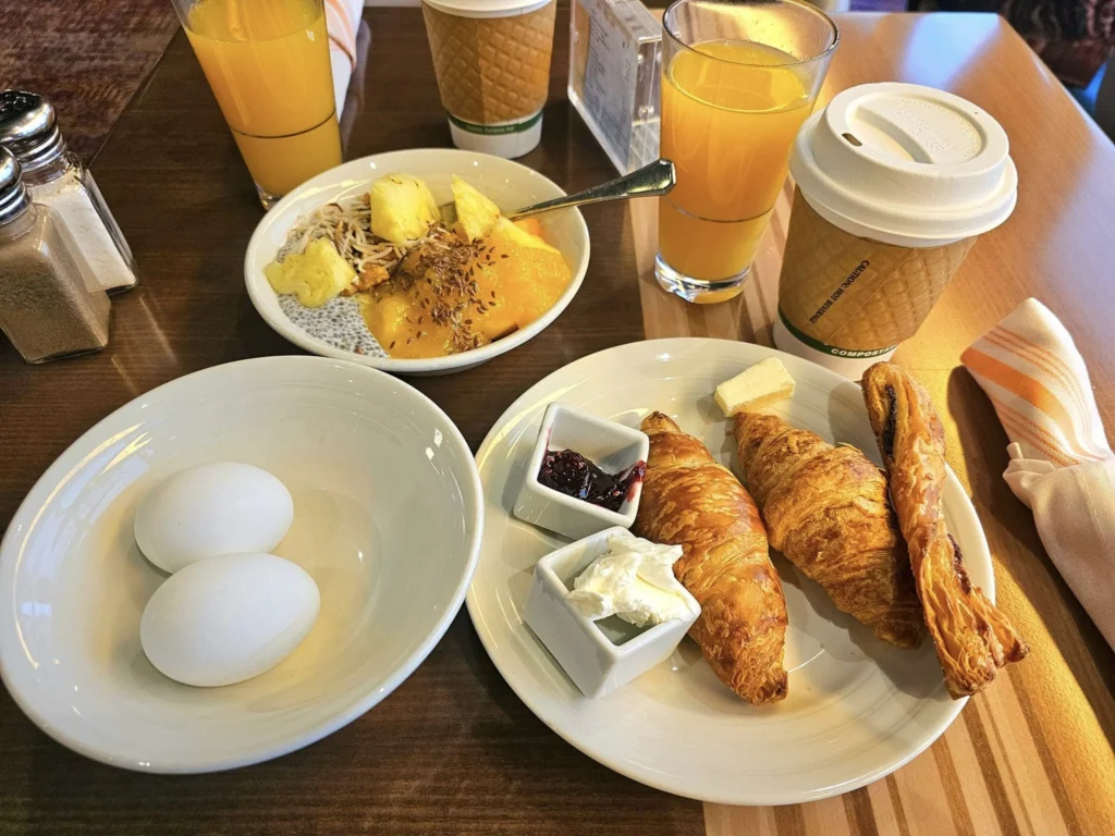 Cruising with Danny and Peter, Holland America Line, Westerdam, Seward, Alaska, United States | A panoramic view of Seward Harbor with rugged cliffs and serene waters, capturing Alaska's wilderness on a photography adventure. Travelers document vibrant wildflowers and snow-capped peaks in Chugach National Forest during an Alaska wilderness cruise. Historical remnants of the 1890 Gold Rush in Seward, including old mining equipment in lush alpine meadows, offer perfect scenes for photography enthusiasts. A majestic bald eagle soars over the tranquil waters of Seward Harbor, while senior-friendly guided tours explore accessible trails amidst stunning natural landscapes.