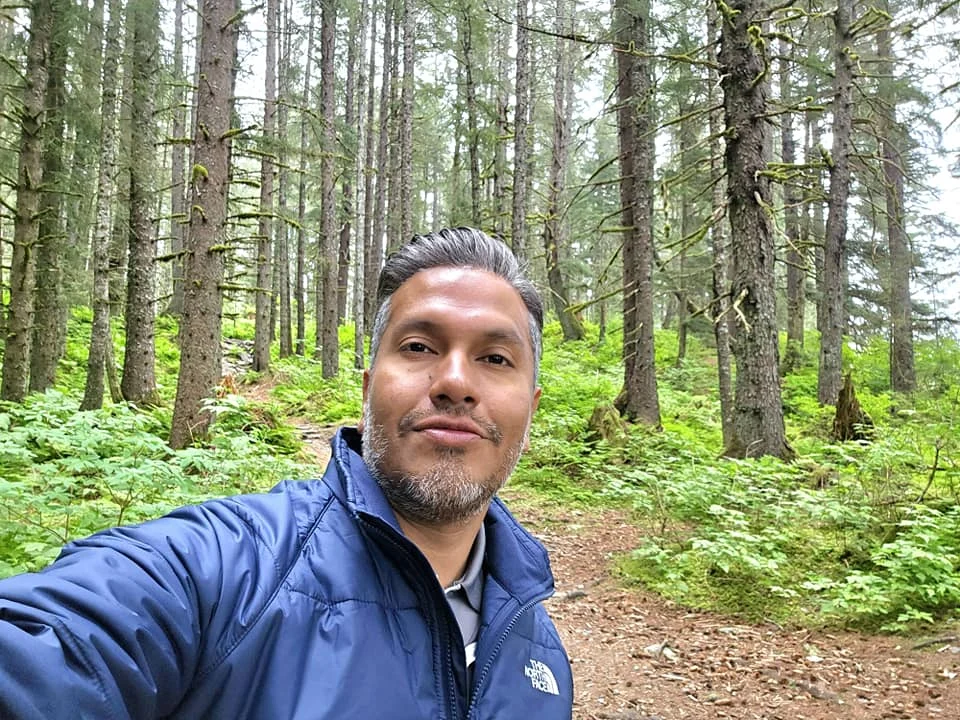 Cruising with Danny and Peter, Holland America Line, Westerdam, Seward, Alaska, United States | A panoramic view of Seward Harbor with rugged cliffs and serene waters, capturing Alaska's wilderness on a photography adventure. Travelers document vibrant wildflowers and snow-capped peaks in Chugach National Forest during an Alaska wilderness cruise. Historical remnants of the 1890 Gold Rush in Seward, including old mining equipment in lush alpine meadows, offer perfect scenes for photography enthusiasts. A majestic bald eagle soars over the tranquil waters of Seward Harbor, while senior-friendly guided tours explore accessible trails amidst stunning natural landscapes.