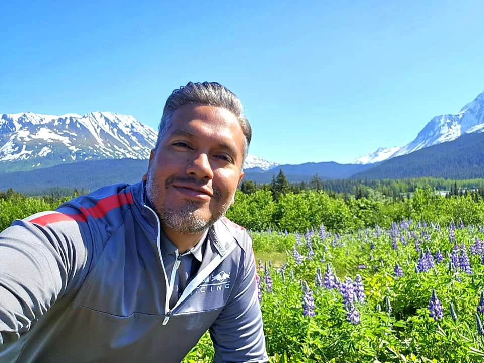 Cruising with Danny and Peter, Holland America Line, Westerdam, Seward, Alaska, United States | A panoramic view of Seward Harbor with rugged cliffs and serene waters, capturing Alaska's wilderness on a photography adventure. Travelers document vibrant wildflowers and snow-capped peaks in Chugach National Forest during an Alaska wilderness cruise. Historical remnants of the 1890 Gold Rush in Seward, including old mining equipment in lush alpine meadows, offer perfect scenes for photography enthusiasts. A majestic bald eagle soars over the tranquil waters of Seward Harbor, while senior-friendly guided tours explore accessible trails amidst stunning natural landscapes.