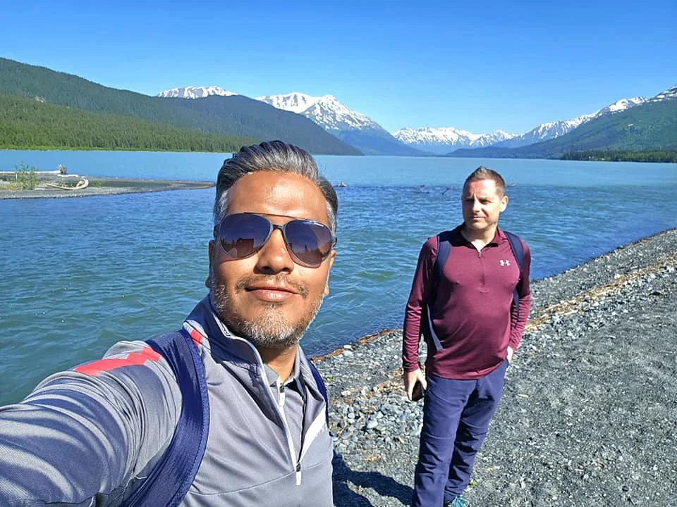 Cruising with Danny and Peter, Holland America Line, Westerdam, Seward, Alaska, United States | A panoramic view of Seward Harbor with rugged cliffs and serene waters, capturing Alaska's wilderness on a photography adventure. Travelers document vibrant wildflowers and snow-capped peaks in Chugach National Forest during an Alaska wilderness cruise. Historical remnants of the 1890 Gold Rush in Seward, including old mining equipment in lush alpine meadows, offer perfect scenes for photography enthusiasts. A majestic bald eagle soars over the tranquil waters of Seward Harbor, while senior-friendly guided tours explore accessible trails amidst stunning natural landscapes.