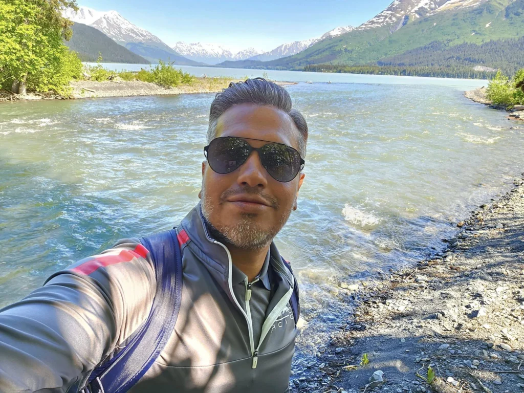 Cruising with Danny and Peter, Holland America Line, Westerdam, Seward, Alaska, United States | A panoramic view of Seward Harbor with rugged cliffs and serene waters, capturing Alaska's wilderness on a photography adventure. Travelers document vibrant wildflowers and snow-capped peaks in Chugach National Forest during an Alaska wilderness cruise. Historical remnants of the 1890 Gold Rush in Seward, including old mining equipment in lush alpine meadows, offer perfect scenes for photography enthusiasts. A majestic bald eagle soars over the tranquil waters of Seward Harbor, while senior-friendly guided tours explore accessible trails amidst stunning natural landscapes.