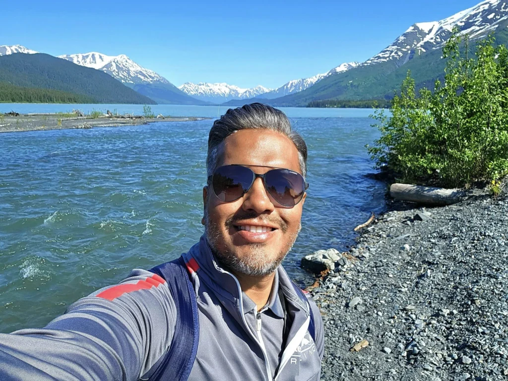 Cruising with Danny and Peter, Holland America Line, Westerdam, Seward, Alaska, United States | A panoramic view of Seward Harbor with rugged cliffs and serene waters, capturing Alaska's wilderness on a photography adventure. Travelers document vibrant wildflowers and snow-capped peaks in Chugach National Forest during an Alaska wilderness cruise. Historical remnants of the 1890 Gold Rush in Seward, including old mining equipment in lush alpine meadows, offer perfect scenes for photography enthusiasts. A majestic bald eagle soars over the tranquil waters of Seward Harbor, while senior-friendly guided tours explore accessible trails amidst stunning natural landscapes.