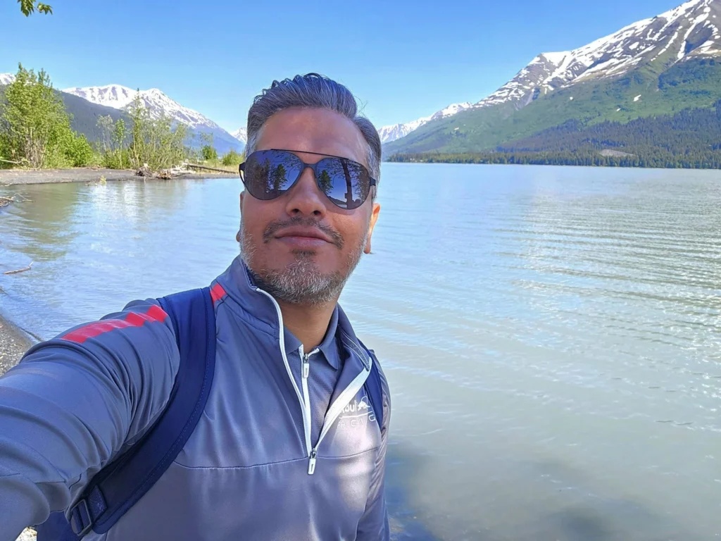 Cruising with Danny and Peter, Holland America Line, Westerdam, Seward, Alaska, United States | A panoramic view of Seward Harbor with rugged cliffs and serene waters, capturing Alaska's wilderness on a photography adventure. Travelers document vibrant wildflowers and snow-capped peaks in Chugach National Forest during an Alaska wilderness cruise. Historical remnants of the 1890 Gold Rush in Seward, including old mining equipment in lush alpine meadows, offer perfect scenes for photography enthusiasts. A majestic bald eagle soars over the tranquil waters of Seward Harbor, while senior-friendly guided tours explore accessible trails amidst stunning natural landscapes.