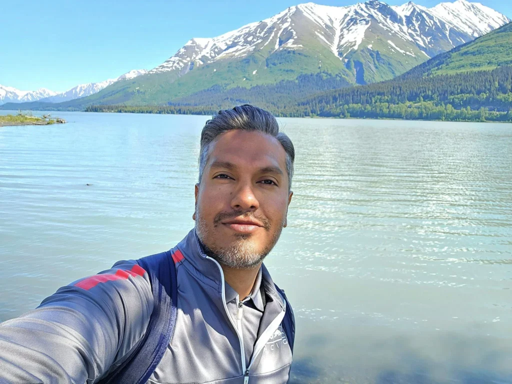 Cruising with Danny and Peter, Holland America Line, Westerdam, Seward, Alaska, United States | A panoramic view of Seward Harbor with rugged cliffs and serene waters, capturing Alaska's wilderness on a photography adventure. Travelers document vibrant wildflowers and snow-capped peaks in Chugach National Forest during an Alaska wilderness cruise. Historical remnants of the 1890 Gold Rush in Seward, including old mining equipment in lush alpine meadows, offer perfect scenes for photography enthusiasts. A majestic bald eagle soars over the tranquil waters of Seward Harbor, while senior-friendly guided tours explore accessible trails amidst stunning natural landscapes.