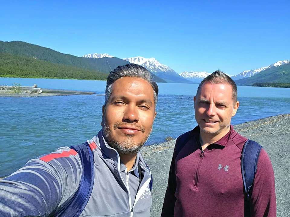 Cruising with Danny and Peter, Holland America Line, Westerdam, Seward, Alaska, United States | A panoramic view of Seward Harbor with rugged cliffs and serene waters, capturing Alaska's wilderness on a photography adventure. Travelers document vibrant wildflowers and snow-capped peaks in Chugach National Forest during an Alaska wilderness cruise. Historical remnants of the 1890 Gold Rush in Seward, including old mining equipment in lush alpine meadows, offer perfect scenes for photography enthusiasts. A majestic bald eagle soars over the tranquil waters of Seward Harbor, while senior-friendly guided tours explore accessible trails amidst stunning natural landscapes.