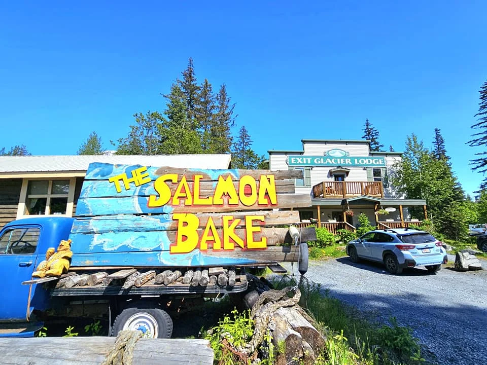 Cruising with Danny and Peter, Holland America Line, Westerdam, Seward, Alaska, United States | A panoramic view of Seward Harbor with rugged cliffs and serene waters, capturing Alaska's wilderness on a photography adventure. Travelers document vibrant wildflowers and snow-capped peaks in Chugach National Forest during an Alaska wilderness cruise. Historical remnants of the 1890 Gold Rush in Seward, including old mining equipment in lush alpine meadows, offer perfect scenes for photography enthusiasts. A majestic bald eagle soars over the tranquil waters of Seward Harbor, while senior-friendly guided tours explore accessible trails amidst stunning natural landscapes.