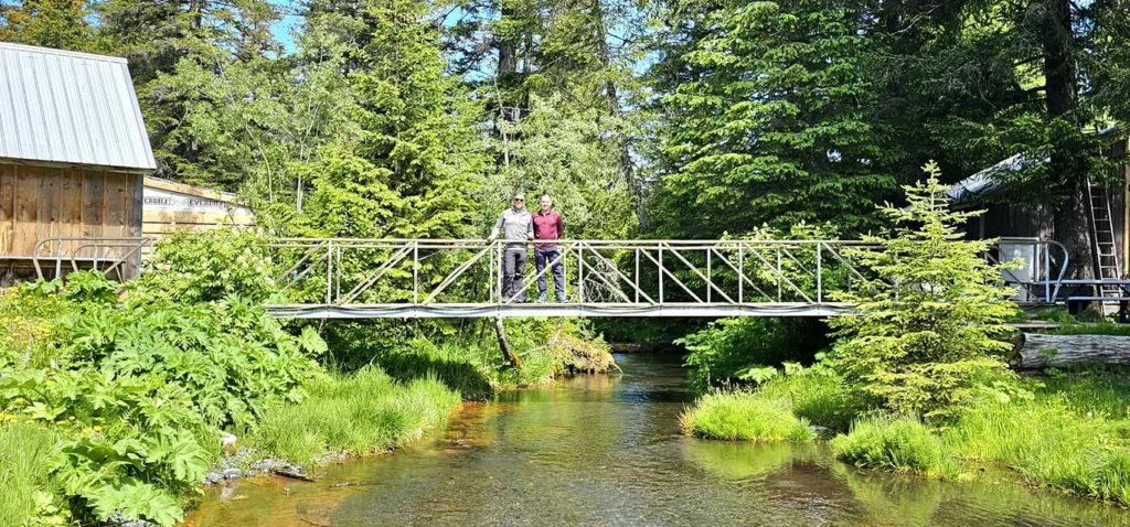 Cruising with Danny and Peter, Holland America Line, Westerdam, Seward, Alaska, United States | A panoramic view of Seward Harbor with rugged cliffs and serene waters, capturing Alaska's wilderness on a photography adventure. Travelers document vibrant wildflowers and snow-capped peaks in Chugach National Forest during an Alaska wilderness cruise. Historical remnants of the 1890 Gold Rush in Seward, including old mining equipment in lush alpine meadows, offer perfect scenes for photography enthusiasts. A majestic bald eagle soars over the tranquil waters of Seward Harbor, while senior-friendly guided tours explore accessible trails amidst stunning natural landscapes.
