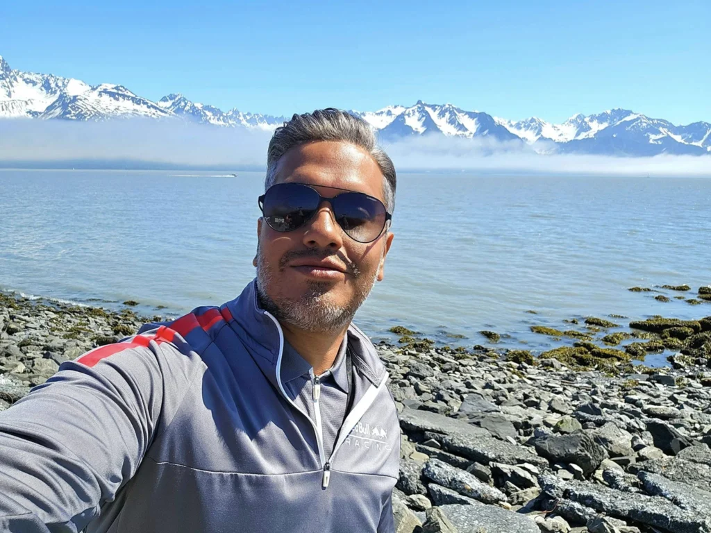 Cruising with Danny and Peter, Holland America Line, Westerdam, Seward, Alaska, United States | A panoramic view of Seward Harbor with rugged cliffs and serene waters, capturing Alaska's wilderness on a photography adventure. Travelers document vibrant wildflowers and snow-capped peaks in Chugach National Forest during an Alaska wilderness cruise. Historical remnants of the 1890 Gold Rush in Seward, including old mining equipment in lush alpine meadows, offer perfect scenes for photography enthusiasts. A majestic bald eagle soars over the tranquil waters of Seward Harbor, while senior-friendly guided tours explore accessible trails amidst stunning natural landscapes.