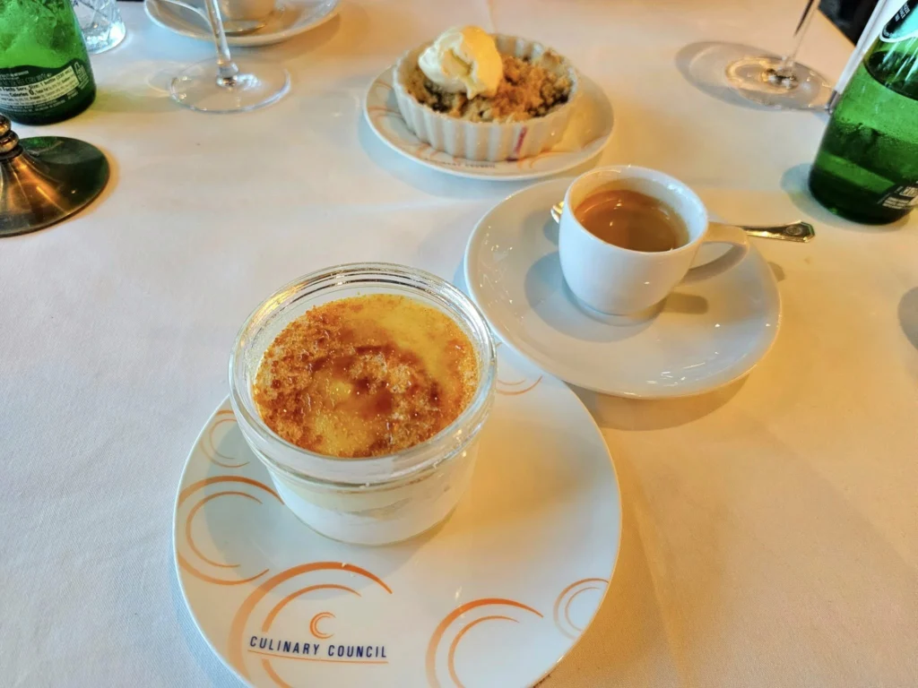 Cruising with Danny and Peter, Holland America Line, Westerdam, Seward, Alaska, United States | A panoramic view of Seward Harbor with rugged cliffs and serene waters, capturing Alaska's wilderness on a photography adventure. Travelers document vibrant wildflowers and snow-capped peaks in Chugach National Forest during an Alaska wilderness cruise. Historical remnants of the 1890 Gold Rush in Seward, including old mining equipment in lush alpine meadows, offer perfect scenes for photography enthusiasts. A majestic bald eagle soars over the tranquil waters of Seward Harbor, while senior-friendly guided tours explore accessible trails amidst stunning natural landscapes.