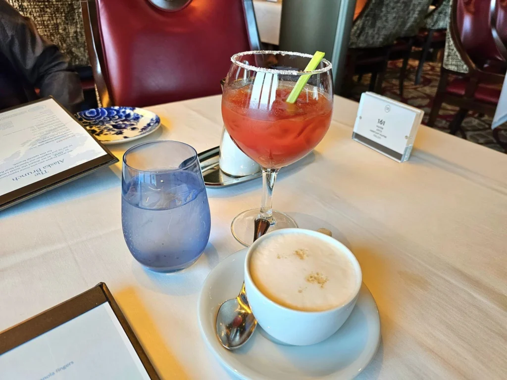 Cruising with Danny and Peter, Holland America Line, Westerdam, Gulf of Alaska, Alaska, United States | Elegant dining room with panoramic ocean views during an Alaska sea day brunch, featuring a spread of gourmet dishes and Alaskan specialties.