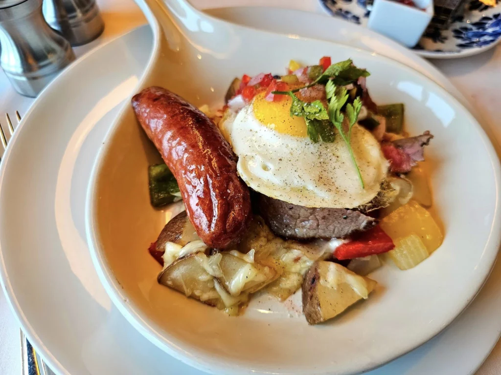 Cruising with Danny and Peter, Holland America Line, Westerdam, Gulf of Alaska, Alaska, United States | Elegant dining room with panoramic ocean views during an Alaska sea day brunch, featuring a spread of gourmet dishes and Alaskan specialties.