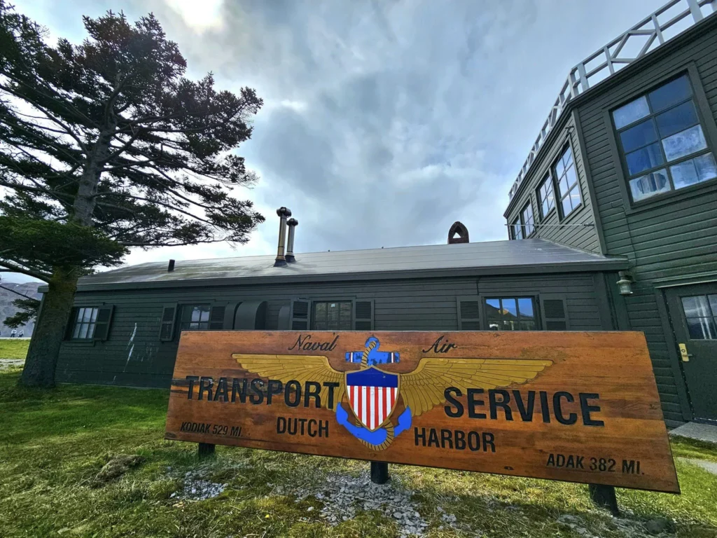 Cruising with Danny and Peter, Holland America Line, Westerdam, Dutch Harbor, Unlaska, Alaska, United States | Scenic view of Dutch Harbor Unalaska featuring rugged mountains and the Bering Sea, with a hiker on Mount Ballyhoo Trail, a majestic bald eagle soaring above, and the historic Russian Orthodox Church with its distinctive onion domes. Includes a fresh seafood dish representing local cuisine and a birdwatching spot at Unalaska Island Bird Sanctuary, capturing the charm of Unalaska's blend of natural beauty, wildlife, and cultural heritage.