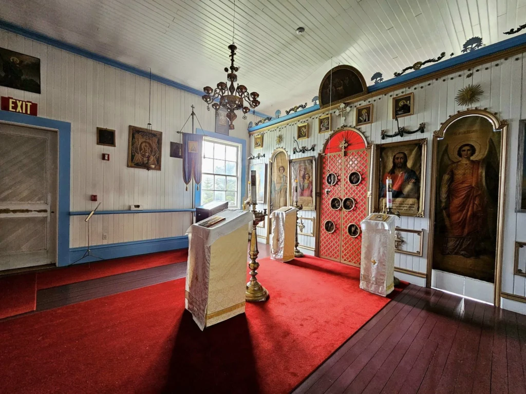 Cruising with Danny and Peter, Holland America Line, Westerdam, Dutch Harbor, Unlaska, Alaska, United States | Scenic view of Dutch Harbor Unalaska featuring rugged mountains and the Bering Sea, with a hiker on Mount Ballyhoo Trail, a majestic bald eagle soaring above, and the historic Russian Orthodox Church with its distinctive onion domes. Includes a fresh seafood dish representing local cuisine and a birdwatching spot at Unalaska Island Bird Sanctuary, capturing the charm of Unalaska's blend of natural beauty, wildlife, and cultural heritage.