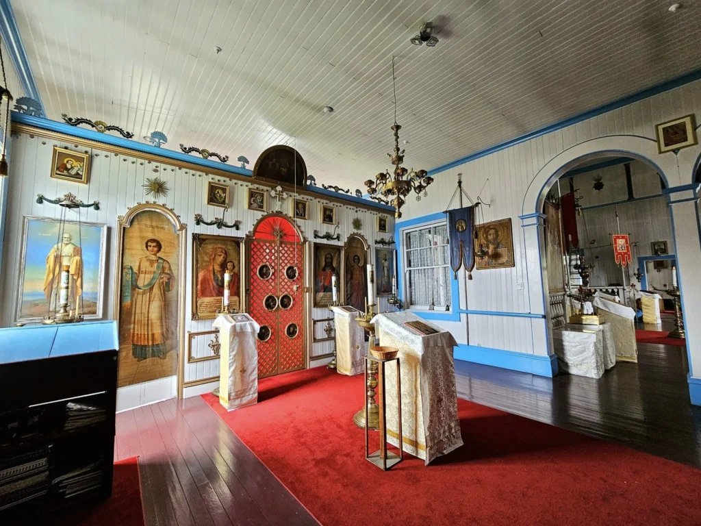 Cruising with Danny and Peter, Holland America Line, Westerdam, Dutch Harbor, Unlaska, Alaska, United States | Scenic view of Dutch Harbor Unalaska featuring rugged mountains and the Bering Sea, with a hiker on Mount Ballyhoo Trail, a majestic bald eagle soaring above, and the historic Russian Orthodox Church with its distinctive onion domes. Includes a fresh seafood dish representing local cuisine and a birdwatching spot at Unalaska Island Bird Sanctuary, capturing the charm of Unalaska's blend of natural beauty, wildlife, and cultural heritage.